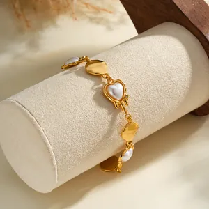 Close-up of French style 18k gold stainless steel bracelet with pearl heart details