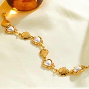 Close-up view of a French style 18k gold plated stainless steel heart pearl bracelet.