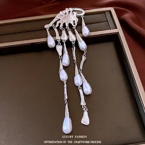 Elegant silver eye brooch with cascading pearl teardrop tassels for luxury fashion style.