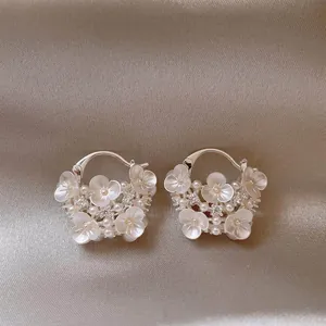 Detailed view of elegant silver-tone flower basket hoop earrings with pearls and crystals