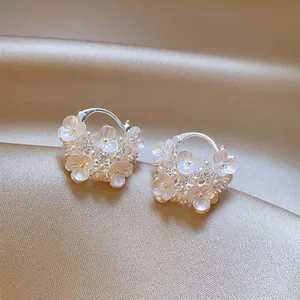 Detailed view of elegant flower basket earrings featuring pearls and white floral accents