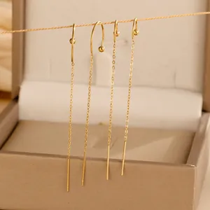 Detail of gold tassel ear threaders with long stainless steel chains in a jewelry box