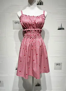Detail view of strawberry print on red gingham dress with ruffled neckline and elastic waist