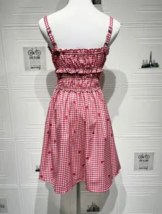 Close-up of red strawberry print and elastic ruffled details on summer sundress