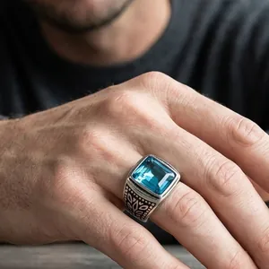 Detailed view of vintage men's ring with square blue gemstone and engraved leaf motifs