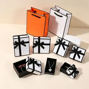 Orange and white jewelry gift boxes with black borders and matching ribbon handles