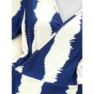 Detail of deep V-neck wrap dress with blue and white zigzag patterns and fine stitching