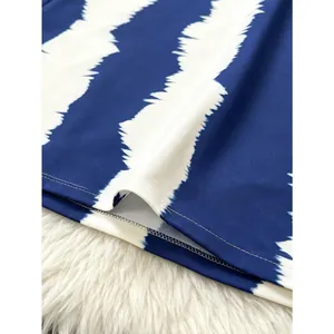 Close-up of blue and white striped hem with scalloped edge on V-neck dress