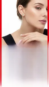Close-up of golden oval stud earrings with clear center stones on a female model