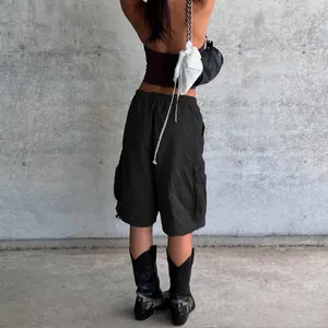 Detail of cargo shorts featuring elastic waistband and large side pockets in charcoal black