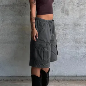 Detail of dark gray cargo shorts featuring elastic waist with drawstrings and large side pockets