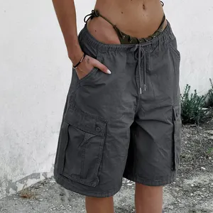 Detail of dark grey cargo shorts featuring side flap pockets and drawstring waist