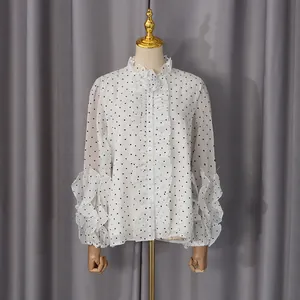 Detail of the layered ruffle cuffs and heart pattern on the white chiffon shirt