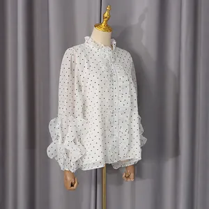 Detail of ruffle stand collar and black heart print on a white long sleeve shirt