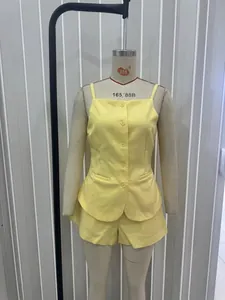 Detail of yellow two-piece set featuring button-up camisole top and matching mini shorts
