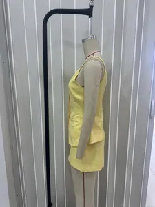 Detail shot of bright yellow button-up vest suit with clean tailored seams
