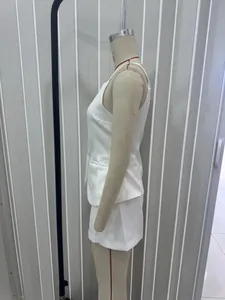 Detailed side view of a white two-piece vest and shorts set on a mannequin model
