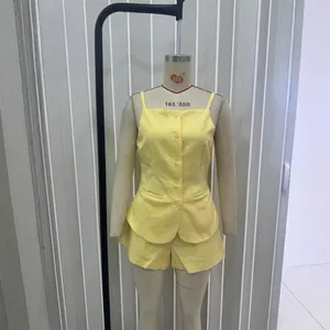 Pale yellow two-piece summer set with button-up camisole top and matching mini shorts