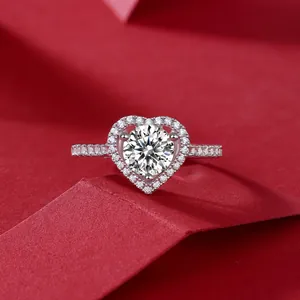 925 silver heart ring with 1 carat round moissanite in halo setting on red background