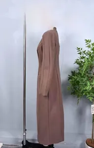Side view detail of a brown long wool coat with side pockets on a mannequin display