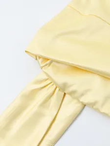 Détail de tissu élastique mat jaune clair avec texture satinée lisse et plis élégants