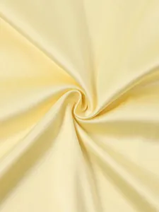 Détail macro du tissu élastique jaune doux avec texture satinée lisse et drapé élégant