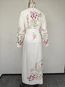 Détail d'une robe longue fleurie à manches longues avec ceinture et poignets élastiques