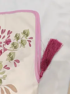 Détail du tissu à imprimé floral vintage avec pompons roses et bordure violette élégante