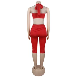 Detail of red backless halter top with large bow tie and slimming leggings set
