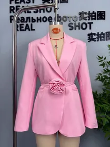 Détail d'un blazer rose orné d'une grande ceinture à motif de rose 3D à la taille