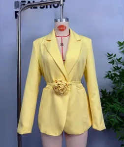 Détail de la fleur 3D et de la ceinture en tissu sur ce blazer long jaune vif