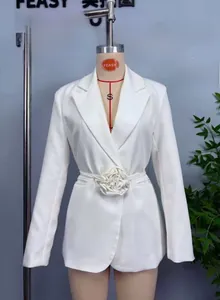 Détail du blazer blanc cintré orné d'une grande rose en tissu 3D à la taille