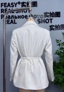 Vue arrière d'un blazer blanc ajusté montrant le détail de la taille nouée réglable
