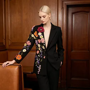 Détail de la broderie florale 3D vibrante sur un blazer noir cintré à boutonnage simple