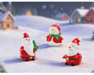 Three festive resin Christmas miniatures featuring Santa Claus and snowman on fake snow