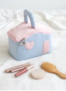 Détail de la trousse de maquillage en forme de maison avec zips en cœur et poignée