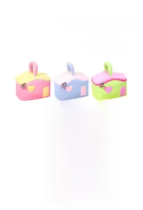 Vue détaillée de trois trousses à maquillage en forme de maison aux couleurs pastel douces
