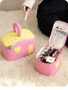 Vue détaillée de la trousse de maquillage rose et jaune avec breloques cœur et anse
