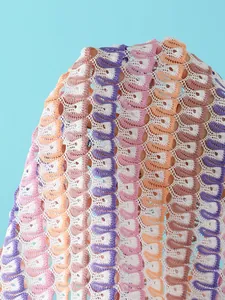 Macro detail of wave-patterned knit fabric with colorful crochet hollow-out design