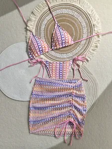Detailed macro view of bohemian three-piece crochet bikini with colorful wave patterns