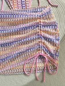 Detail of crochet beach skirt with colorful wave stripes and side pink drawstring closure