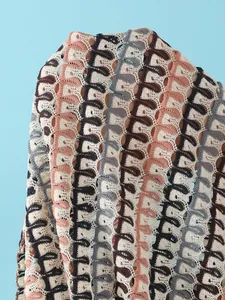 Detailed macro view of multi-color wavy crochet knit fabric with hollow mesh texture