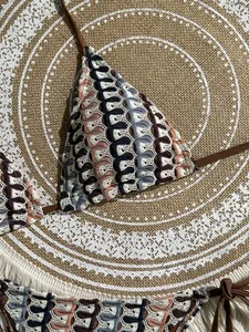 Close-up of bohemian crochet bikini with wave texture and braided side ties detail