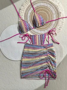 Flat lay of colorful crochet bikini and drawstring skirt with boho wave patterns