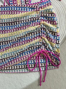 Detail of colorful crochet bikini skirt with side drawstring and bohemian knit texture