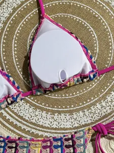 Detail of crochet bikini top with built-in pads and multicolor logo pattern texture
