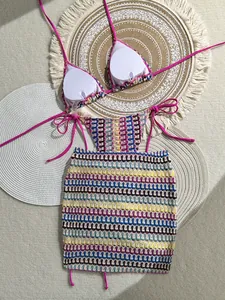 Detailed macro view of bohemian crochet pink bikini top and multicolor striped knit skirt
