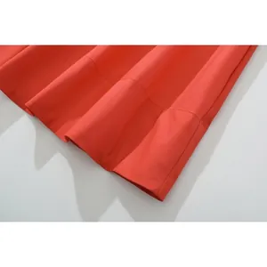 Detailaufnahme der breiten Saumnaht am orange-roten Maxikleid aus gewebtem Stoff