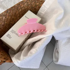 Detailed view of a pink acetate hair claw clip placed in a cozy home lifestyle setting