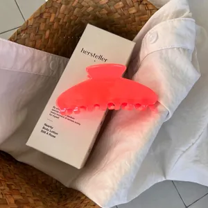 Detailed view of a large neon pink jelly hair claw clip on a white minimalist box